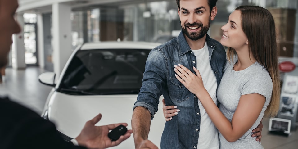 Pareja recibiendo las llaves de su vehículo  seminuevo Chevrolet por el programa auto  confianza