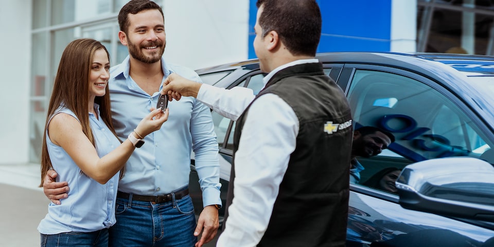 Pareja recibiendo las llaves de su Chevrolet  Seminuevo con garantía y certificado