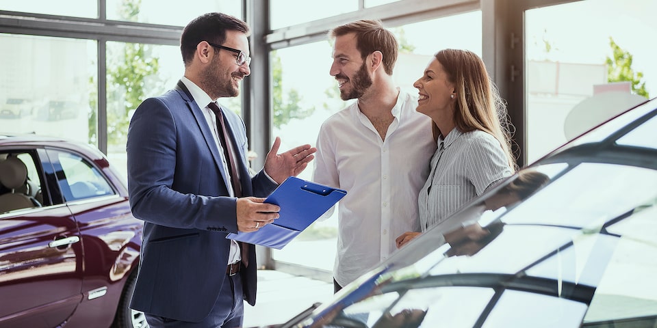 Pareja informándose sobre los vehículos  seminuevos disponibles con nuestros  distribuidores